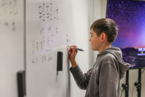 Boy practicing Mandarin on a class whiteboard