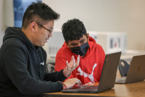 Instructor helping a student on his computer