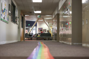 Rainbow tape running through the center of a hallway